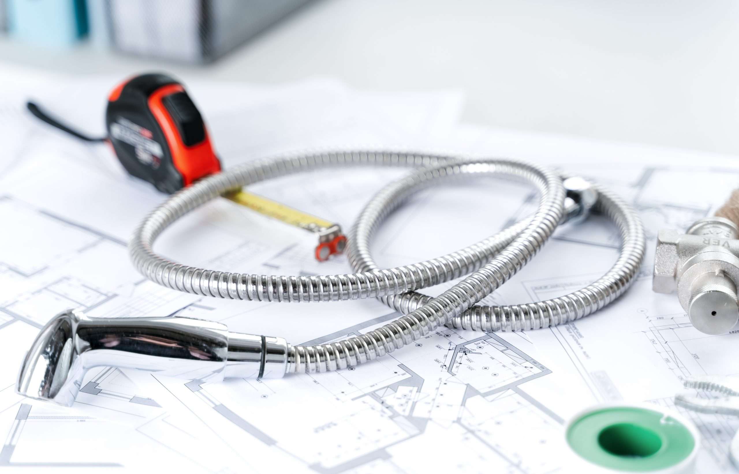 Plumbing project in house.Drawing,diagrams,plan of water supply of apartment,building.Man repairer making repairs at home.Devices,accessories, hose,tap,adjustable wrench,pressure reducer,tape measure